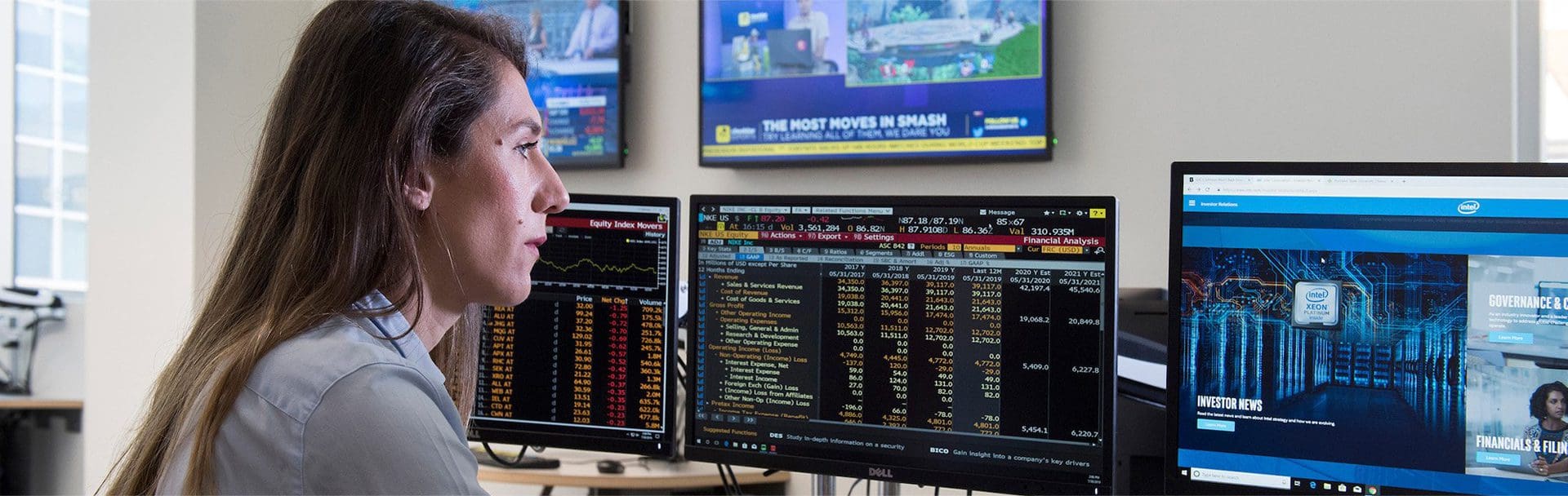 A person standing in front of two monitors.