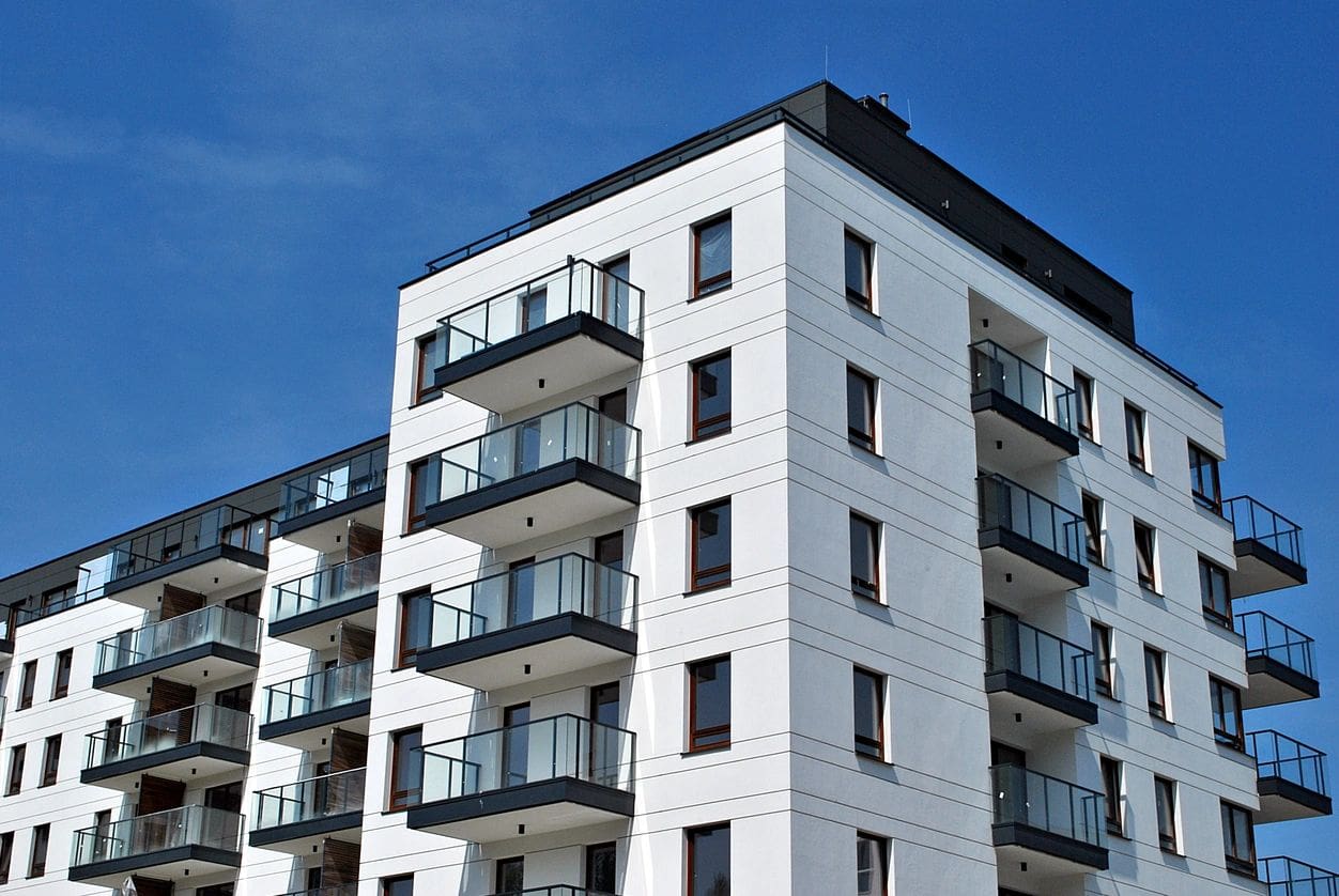 A white building with balconies on the top of it.